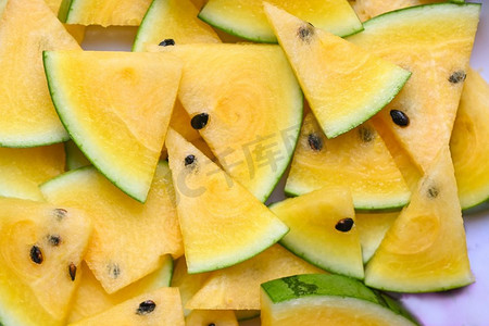 黄色西瓜片在背景，特写镜头堆甜的西瓜片片新鲜的西瓜热带夏天水果—顶视图