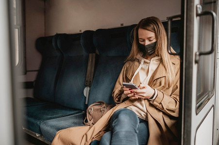 戴着医用口罩坐在火车上的女乘客衣架抹胸