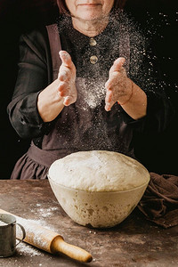 女厨师在处理披萨面团之前先在手上撒上面粉