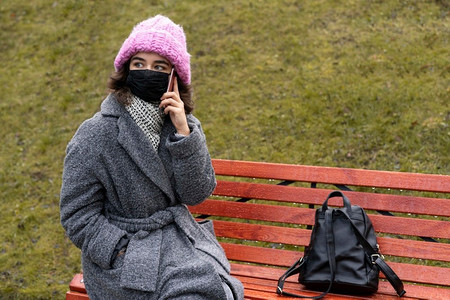 女子带医用口罩城市通话电话板凳