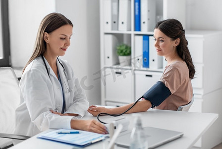 医学,医疗保健和人的概念-女医生在医院用眼压计测量女病人的血压.