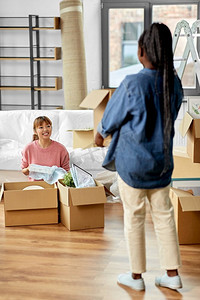 移动，人和房地产概念—妇女打开箱子在新家。妇女打开箱子和搬到新家