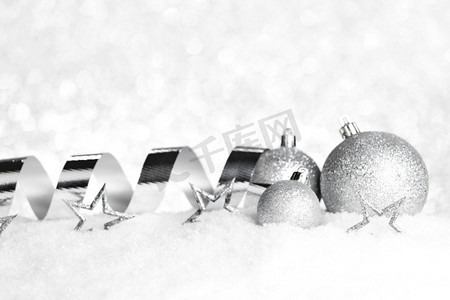 银色圣诞装饰在雪特写镜头。圣诞节装饰在雪地上