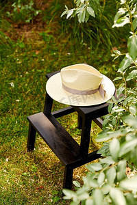 休闲与物件概念-夏园凳子上的草帽特写。夏日花园凳子上的草帽合影