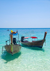 岩石海滩摄影照片_泰国美丽的热带海滩与长尾船