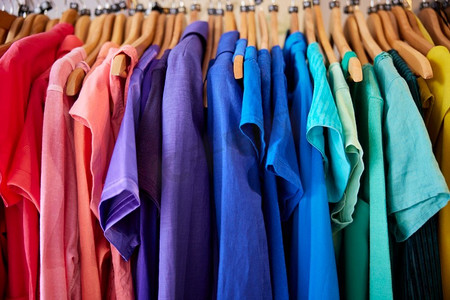 彩色可持续服装挂在铁路上的慈善或廉价商店销售可持续时尚