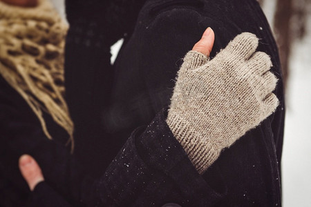 一男一女穿着保暖的衣服，戴着围巾，在雪林和田野中散步
