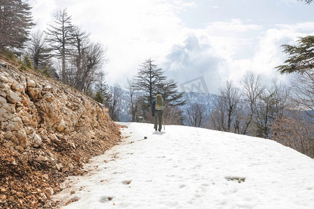 登山徒步的人摄影照片_冬季森林中的徒步旅行者