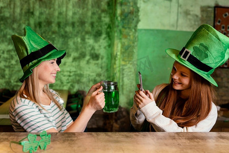 快乐的女性朋友一起庆祝圣帕特里克节酒吧与饮料