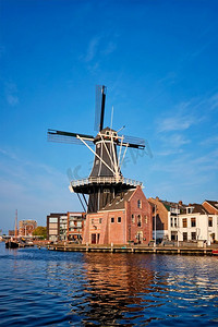 哈莱姆城市景观--斯帕恩河上地标性的风车de Adriaan，有船。荷兰哈莱姆区。荷兰哈莱姆区全景