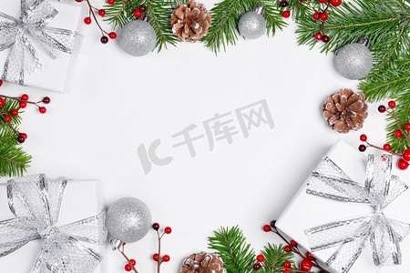 圣诞树分支与雪，松果，红色浆果和礼品盒在白色背景与拷贝空间的圣诞树分支圣诞礼品盒和装饰