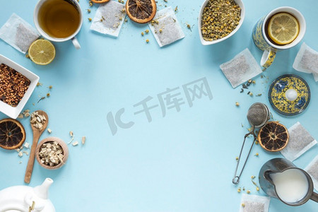 高架视图柠檬茶草药牛奶过滤器干中国菊花花茶壶茶袋安排蓝色背景