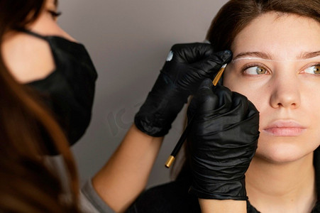 前视图妇女得到眉毛治疗从女性临床医生