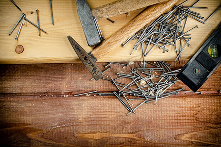 桌子上有一堆钉子的锤子。在一个木制的背景。高质量的照片。桌子上有一堆钉子的锤子。 