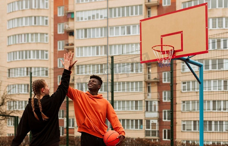 打篮球操场摄影照片_在户外打篮球的青少年