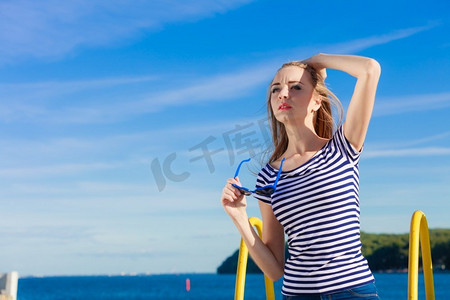 夏季放松概念肖像女孩与蓝色心形太阳镜享受夏天微风室外在天空背景