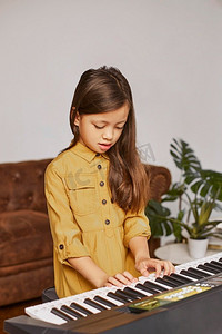 年轻女孩学习如何玩电子键盘