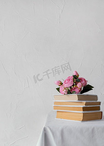 白色小插图摄影照片_用书籍堆放鲜花的插图