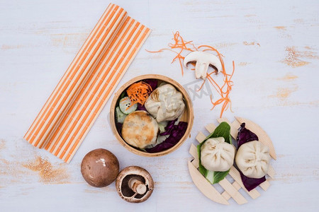 白色中式摄影照片_中式蒸点心竹容器传统菜肴白色木桌