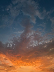 美丽的日落天空与五颜六色的橙色云彩在地平线，垂直的天体背景