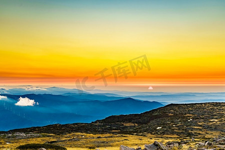 景观云层摄影照片_在云层之上燃烧的日落。从葡萄牙的塞拉达埃斯特雷拉的托雷山峰上的景色。燃烧的日落在云层之上，塞拉达埃斯特雷拉，葡萄牙。