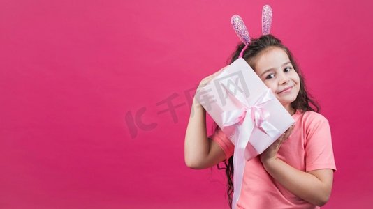 兔耳朵背景摄影照片_女孩兔耳朵拿着礼品盒
