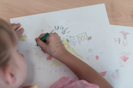 小女孩坐在小学纸上画画。高质量的照片。小女孩坐在小学绘画纸 