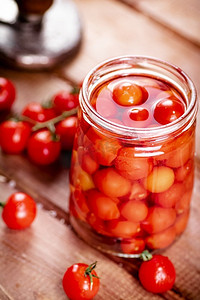 保守摄影照片_在玻璃罐里腌熟西红柿。在一个木制的背景。高质量的照片。在玻璃罐里腌熟西红柿。 