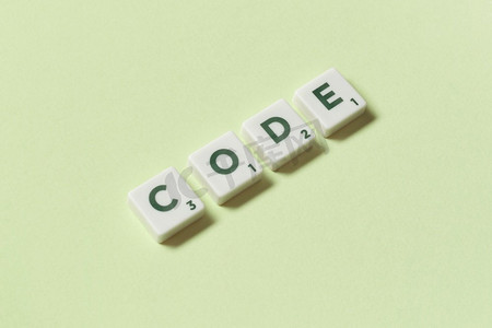 代码字形成的拼字元素在绿色背景，静止的生活与复制空间。代码形成的拼字游戏元素在绿色背景。