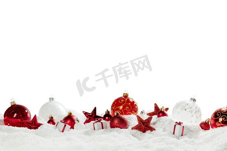 饰物摄影照片_圣诞节组成红色球小饰物星在雪隔绝在白色背景边界框架设计元素。圣诞节红色球在雪