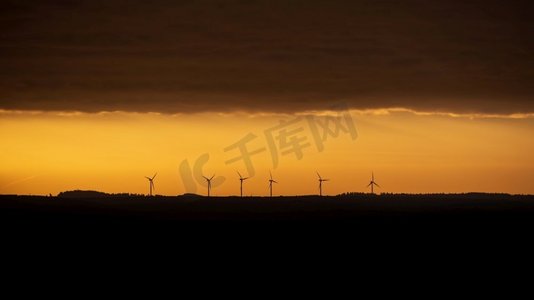 忧郁摄影照片_忧郁的风景日出图像风力涡轮机反对深橙色天空