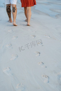 沙滩衣服摄影照片_年轻夫妇橙色衣服与狗在空沙滩