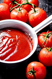 番茄酱与成熟的新鲜西红柿在树枝上。黑色背景。高质量的照片。番茄酱与成熟的新鲜西红柿在树枝上。 