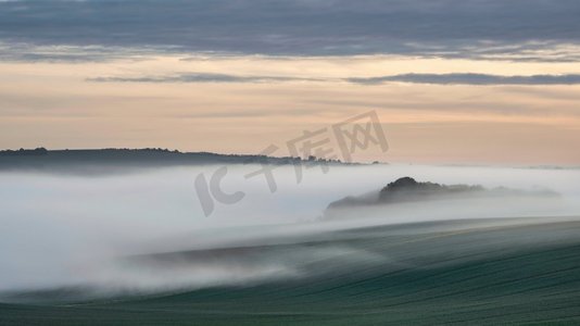 春天的日出时，雾海在英国南部唐斯乡村翻滚的美丽风景