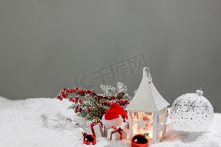 圣诞装饰与蜡烛在灯笼小玩意儿和礼物在雪。圣诞装饰灯笼