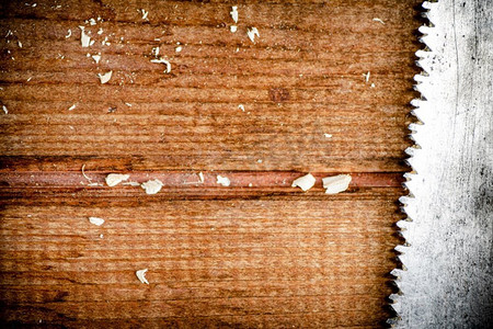 质量仪器摄影照片_木质背景上的手锯刀片。高质量的照片。木质背景上的手锯刀片。