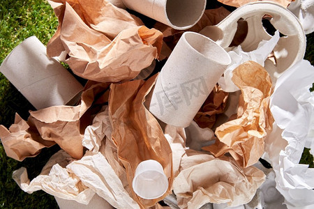回收、垃圾处理、环境生态理念--草地上皱巴巴的废纸特写。草地上皱巴巴的废纸特写