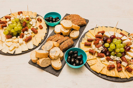 橄榄框摄影照片_不同类型的面包片橄榄拼盘奶酪木桌子