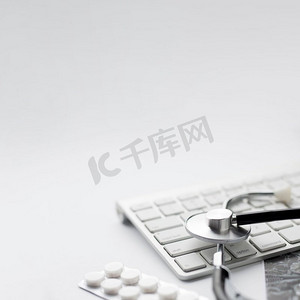 泡罩包装药丸听诊器与无线键盘白色背景