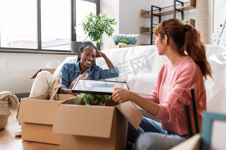 移动，人和房地产概念—快乐的微笑妇女打开箱子在新家。妇女打开箱子和搬到新家
