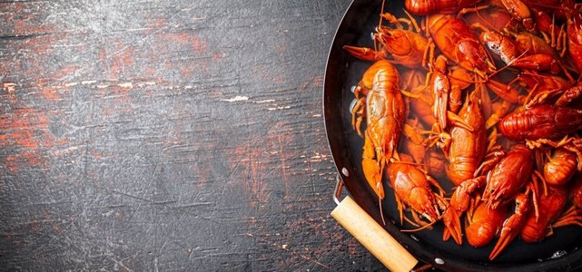 小龙虾在平底锅里煮。在黑暗的背景下。高质量的照片。小龙虾在平底锅里煮。 