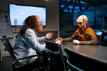 僵尸怪物摄影照片_在公司办公室开僵尸商务会议。两个商人在会议室里的怪物团队合作。僵尸商务会议在公司办公室