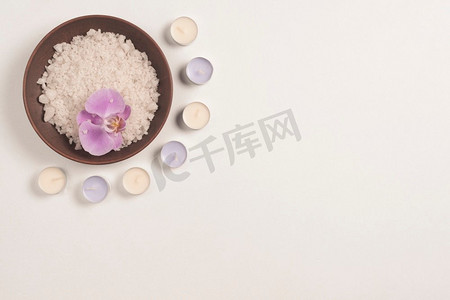 碗浴盐与兰花花装饰蜡烛白色背景