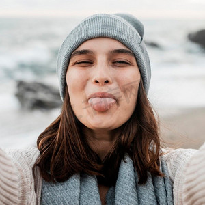 愚蠢的女人在海滩上自拍手编帽美女