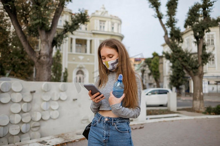 前视图妇女与医用口罩持有瓶装水