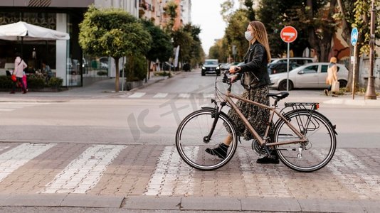 马路循环摄影照片_女人过马路她的自行车