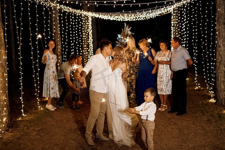 婚礼舞蹈摄影照片_新婚夫妇婚礼上的火花在欢乐的客人手中