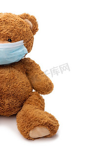 医药、保健和流行病概念-白色背景下戴着防护医用口罩的泰迪熊玩具。戴着防护医用口罩的泰迪熊玩具
