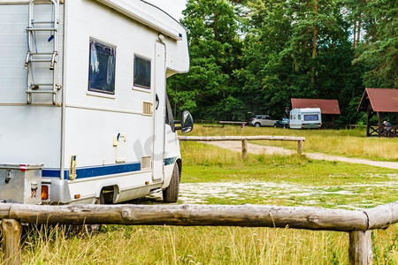 乘汽车旅行摄影照片_露营者露营在夏天的大自然。乘汽车回家。大篷车度假..露营在自然
