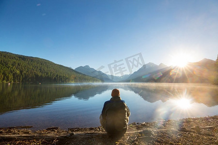 一个人在平静的湖边安心休息.湖泊山峦